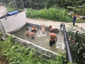 Kamyonun kasasına su doldurup serinlediler