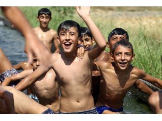 Sıcaktan bunalan Adanalılar sulama kanalına akın etti