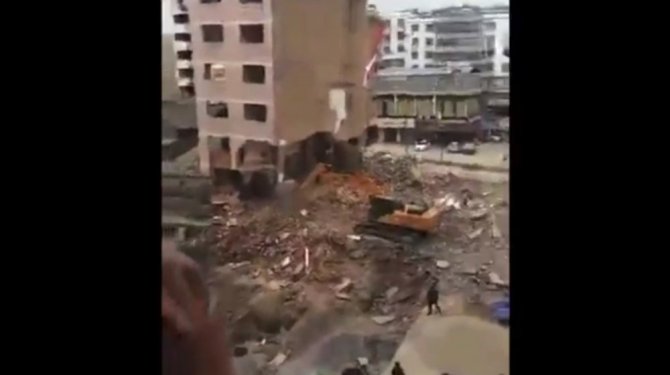 Bir anda yıkılan bina, iş makinesinin üzerine çöktü