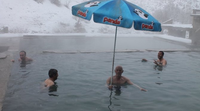 Vatandaşlar, etrafı karlarla çevrili kaplıcada yüzmenin keyfini çıkarıyor