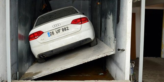 ASANSÖR BOŞLUĞUNDAKİ OTOMOBİLİNİ ÇIKARMAK İÇİN DAVAYI BEKLİYOR