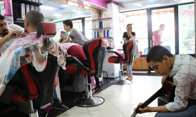 Canlı müzik eşliğinde müşterilerini tıraş ediyor