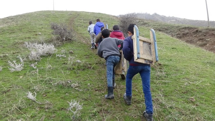 Çamurda kızaklarla doyasıya eğleniyorlar