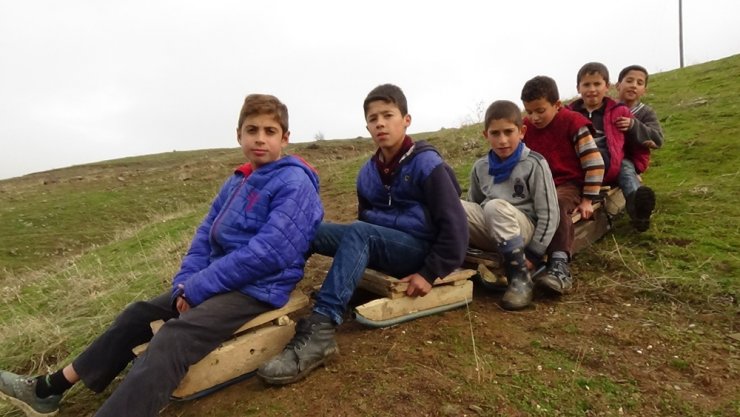 Çamurda kızaklarla doyasıya eğleniyorlar