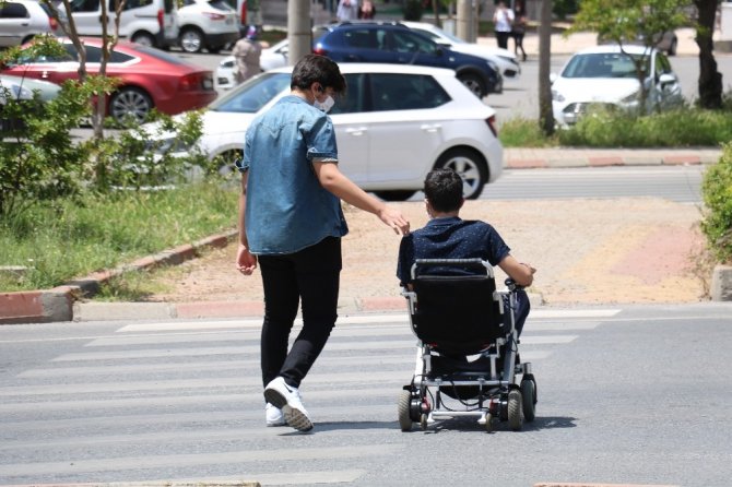 Kahramanmaraşlı genç, sokağa çıkardığı engelli kuzeni ile yürüyüş yaptı